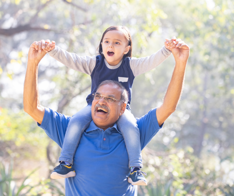 A Granddad holding his granddaughter on his shoulders