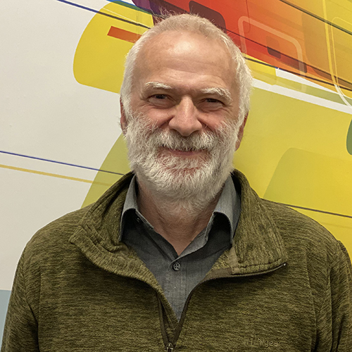 Head shot of man with short grey hair and a grey beard
