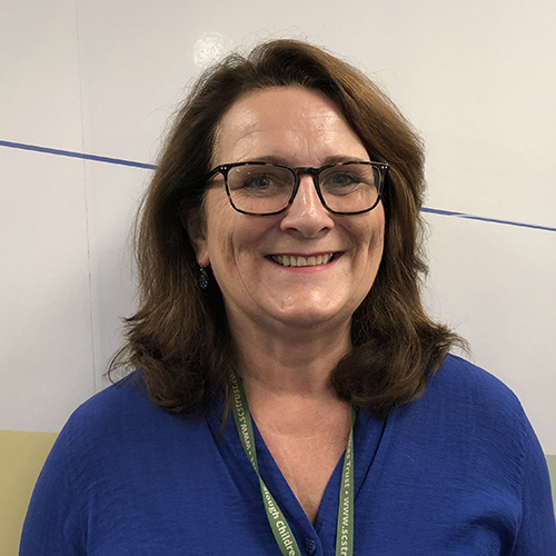 Head shot of women with shoulder length brown hair and wearing glasses