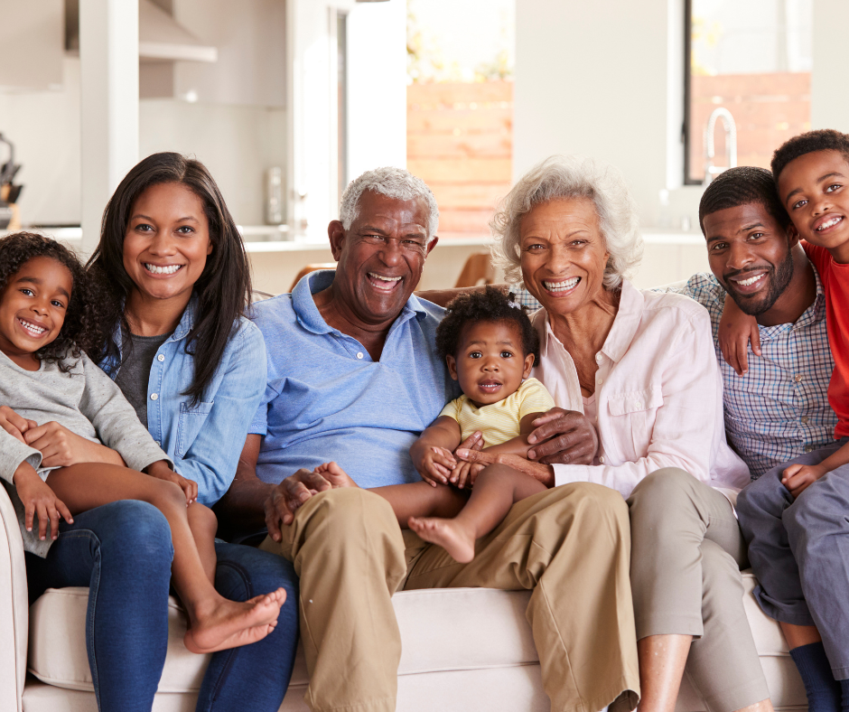 Multi generational family sitting on a sofa smiling